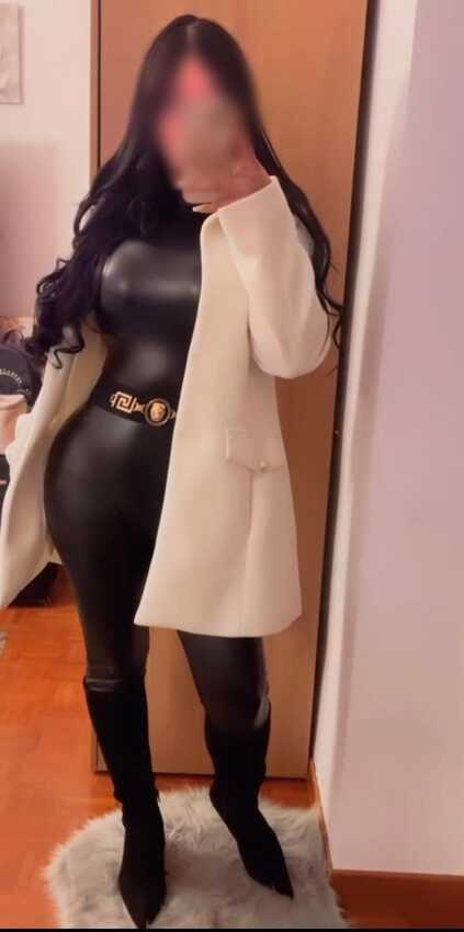 Natasha, escort, indossa un cappotto color crema su Velazquez24