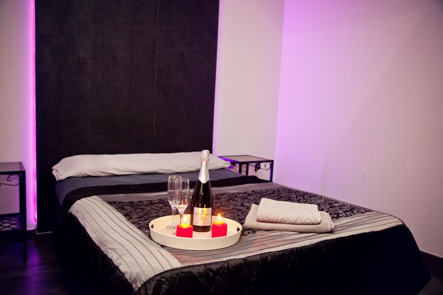 Room with bed and decorative red lighting in a sexclub in Malaga