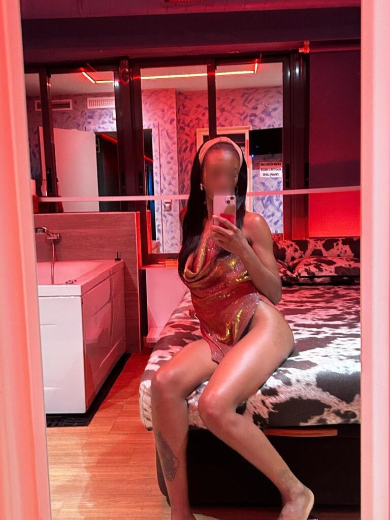 Amber, the escort at Velazquez24, poses in front of a mirror in a sparkling dress at the age of 35 Amber, the escort at Velazquez24, poses in front of a mirror in a sparkling dress at the age of 35