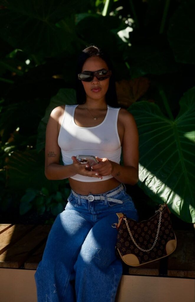 Jade, una escort, indossa dei jeans blu con una cintura luccicante e tiene in mano un cellulare a Malaga Jade, una escort, indossa dei jeans blu con una cintura luccicante e tiene in mano un cellulare a Malaga