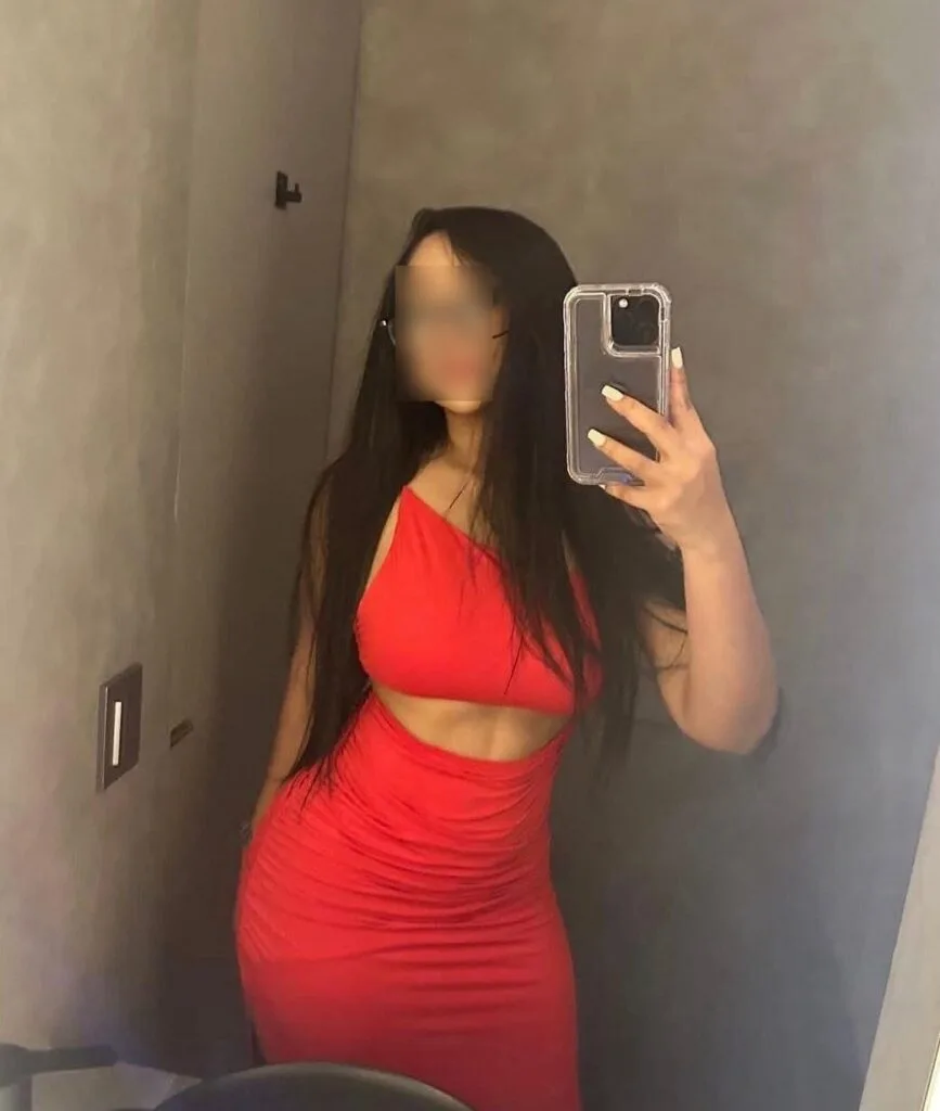 Monica, een 25-jarige escort, poseert in een rode jurk voor de spiegel in Malaga Monica, een 25-jarige escort, poseert in een rode jurk voor de spiegel in Malaga