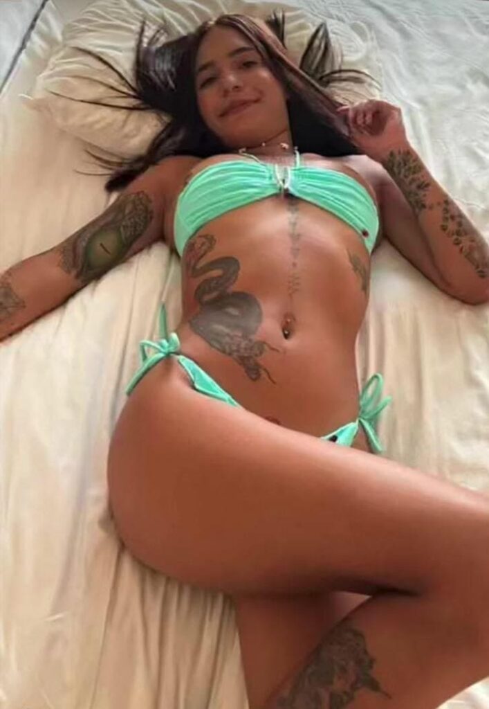 Paulina, une escort, pose en bikini vert, allongée sur un lit à Malaga