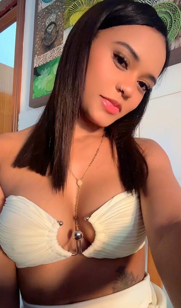 Alison, a 26-year-old escort, takes a selfie wearing a white top in Malaga