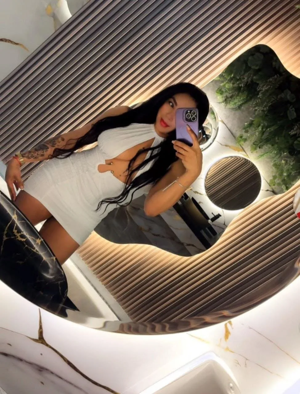 Megan, escort lleva un vestido blanco corto con aberturas en Málaga