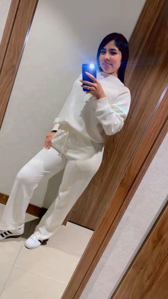 Chloe, escort lleva una sudadera blanca y pantalones de chándal a juego en Malaga
