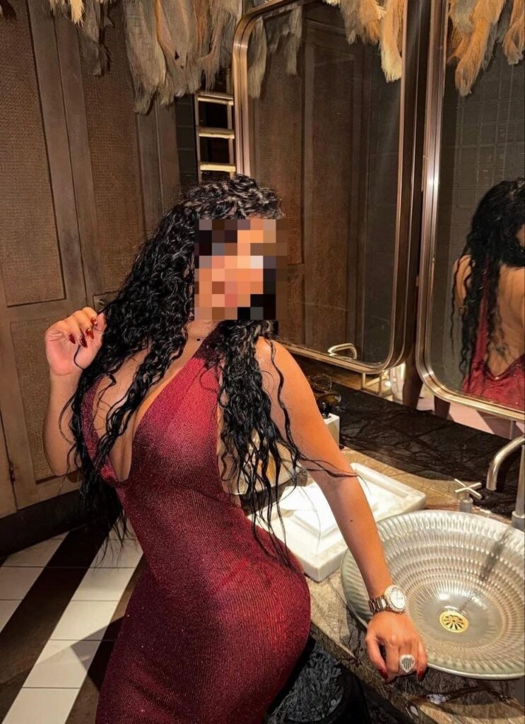 Tatiana, escort posa en un baño con un vestido largo en Malaga